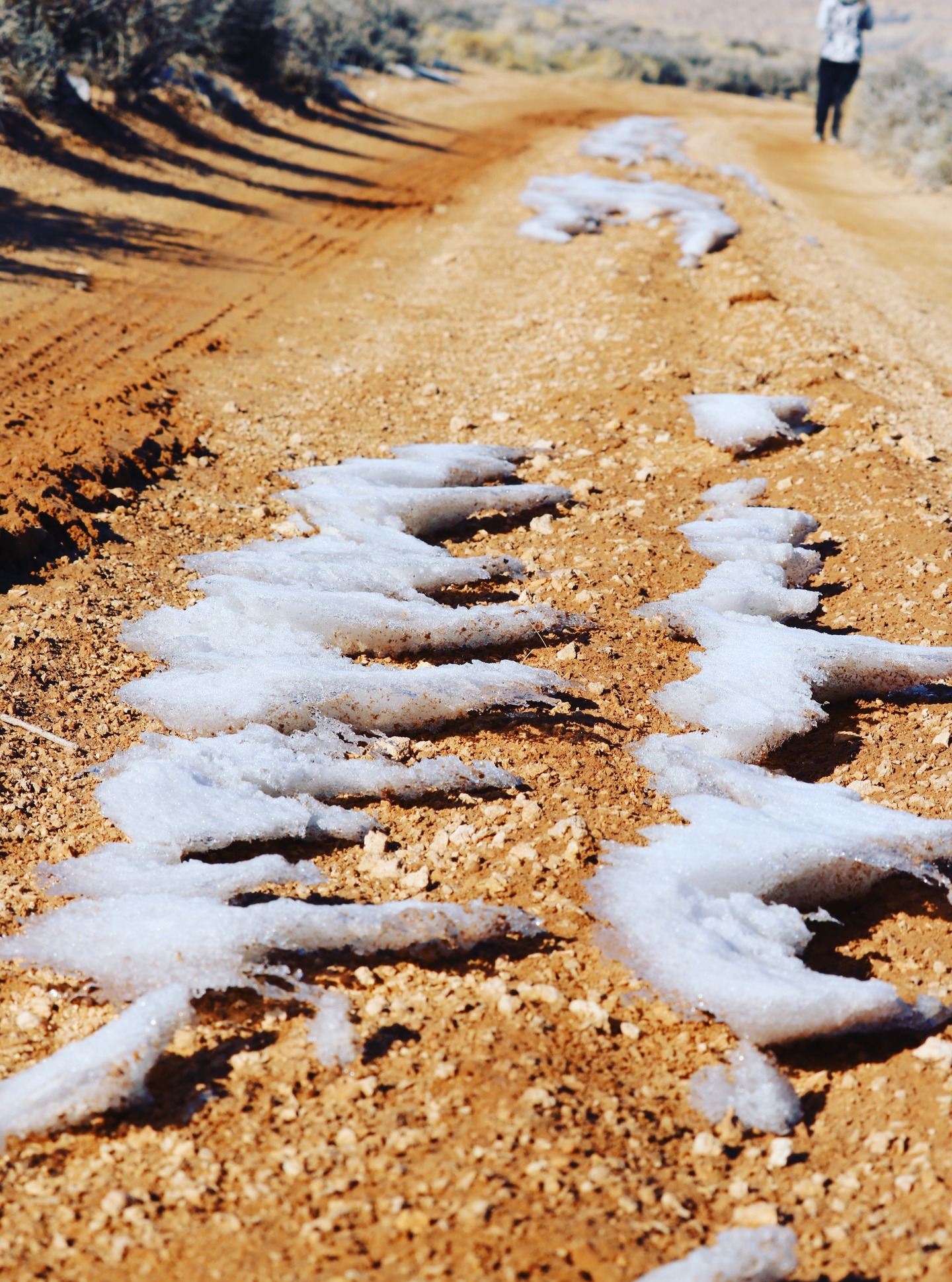 The snow melted in such a way that it looks like cirrus clouds floating over the dirt road. Hiking to #SkylightArch in the winter wonderland of Southern #Utah #nature #snow #hiking
