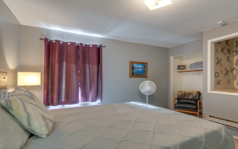 main bedroom with memory foam queen, leather chair and closet storage space